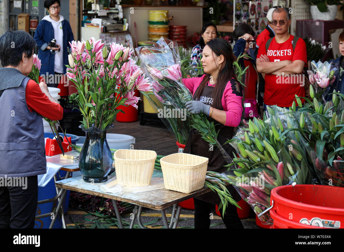 Florist verkaufen Blumenstrauß der blühenden Blumen zu Kunden im Flower Market Road in Mong Kok, Hong Kong Stockfoto