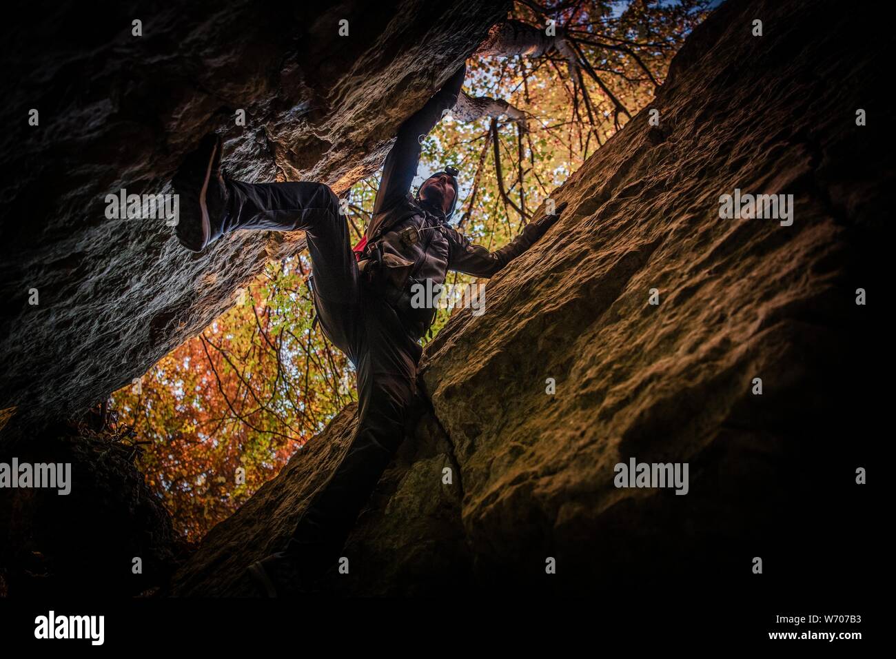 Extreme Cave Exploration durch Kaukasische Sportler. Klettern zwischen zwei Felswände. Stockfoto
