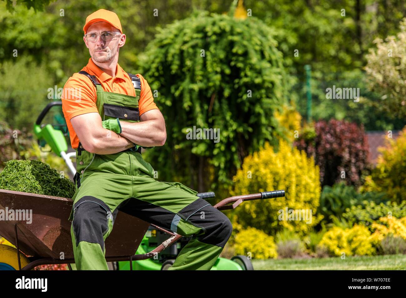 Professionelle Gärtner Job. Zufrieden kaukasischen Garten Arbeiter in seinem 30s Entspannen während Mitte Tag der Arbeitsunterbrechung. Landschaftsbau Industrie. Stockfoto