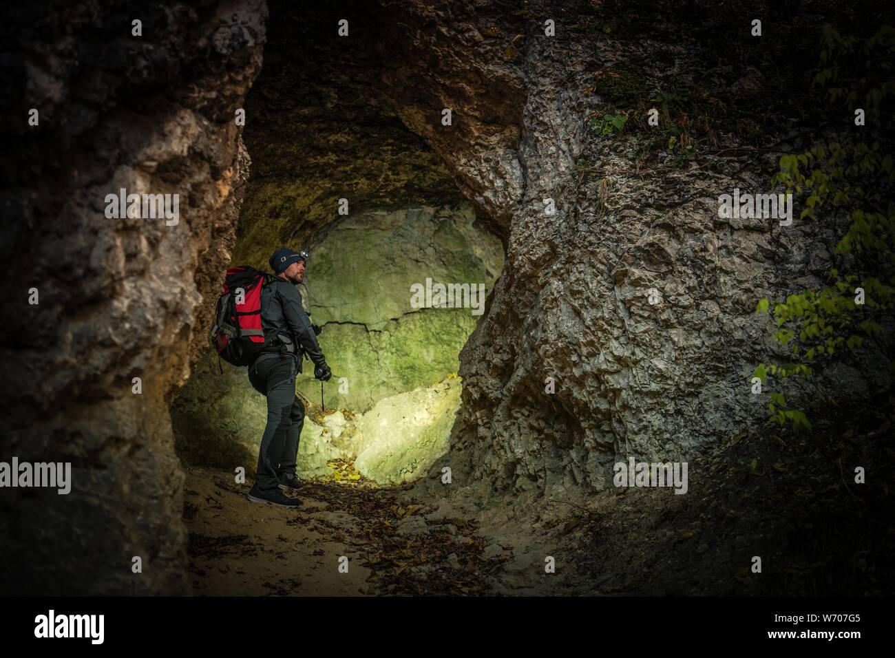 Enge Höhle Expedition. Kaukasische Männer erkunden Felsformationen. Abenteuer und Lifestyle Thema. Stockfoto