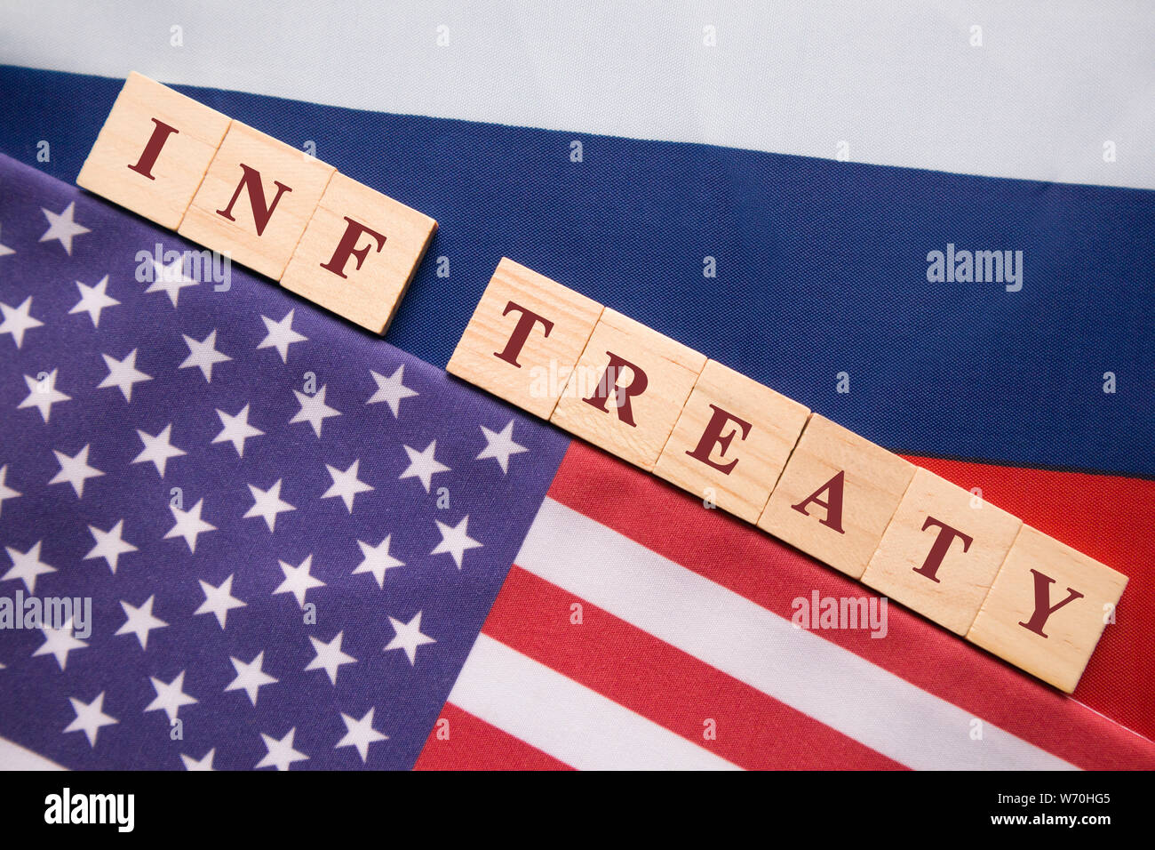 INF-Vertrag geschrieben Holzblock Buchstaben in zwischen den amerikanischen und den russischen Flagge, Konzept des INF-Vertrags durch die USA und Russland unterzeichnet. Stockfoto