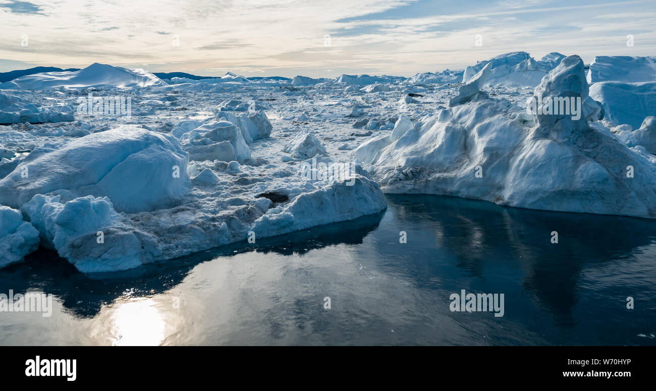 Antenne drone Bild des Eisbergs und Eis von Gletscher in der Arktis Natur Landschaft auf Grönland. Luftbild Drohne Foto von Eisbergen in Ilulissat Eisfjord. Durch den Klimawandel und die globale Erwärmung betroffen. Stockfoto