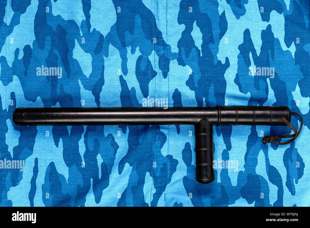 Gummi schwarz Baton auf Blau urban russischen Bereitschaftspolizei camouflage Flach "top-down"-Perspektive. Stockfoto