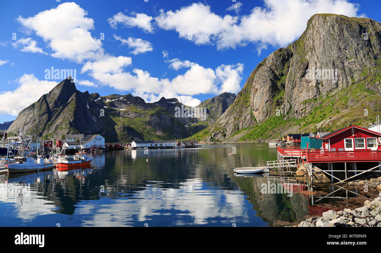 Traditionelle norwegische Fischerboote und Häuser in Lofoten Insel, Reine Gegend mit schönen Reflexionen im Ozean Fjord Stockfoto