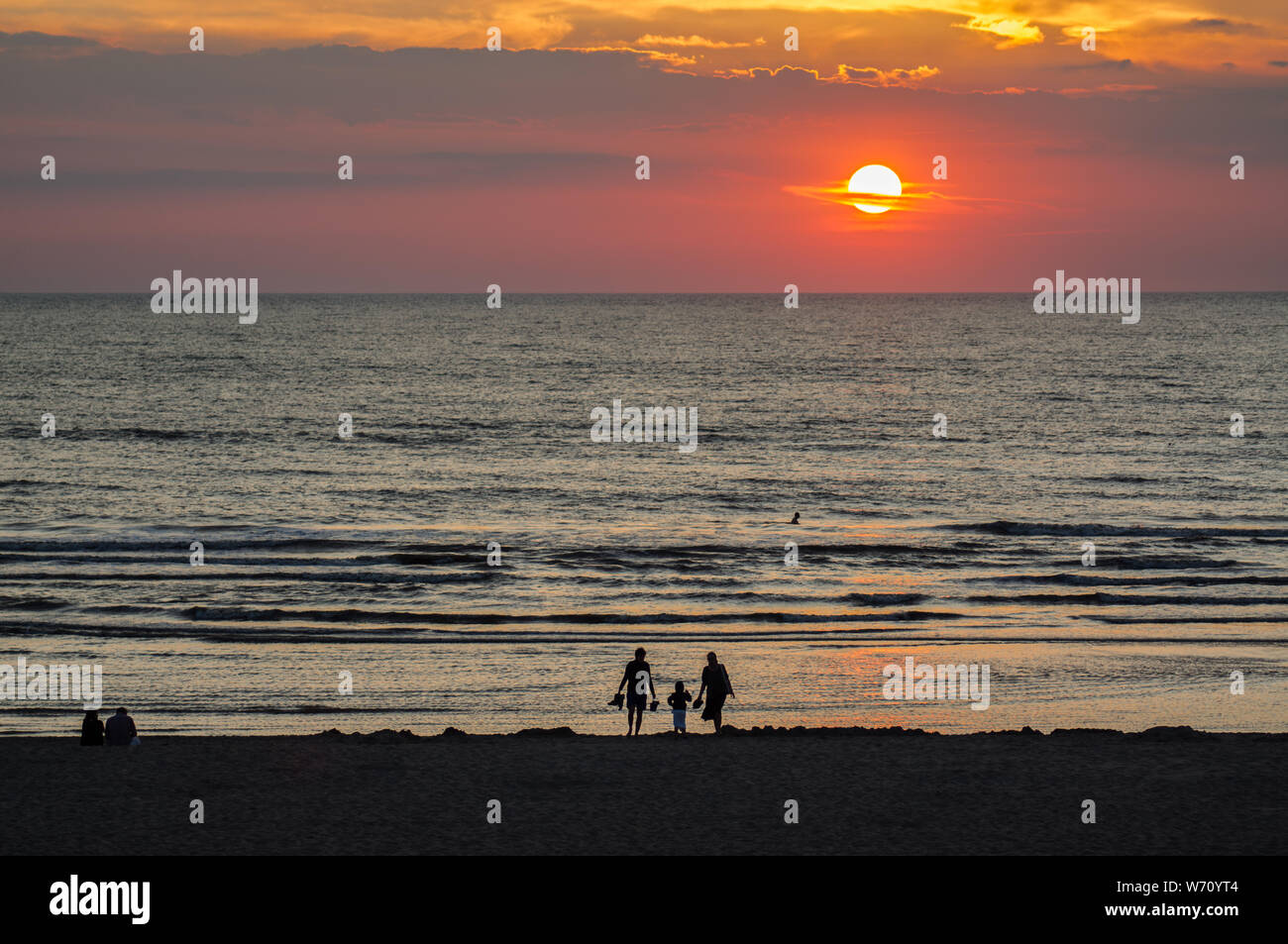 Familie am Strand bei Sonnenuntergang Zeit Stockfoto