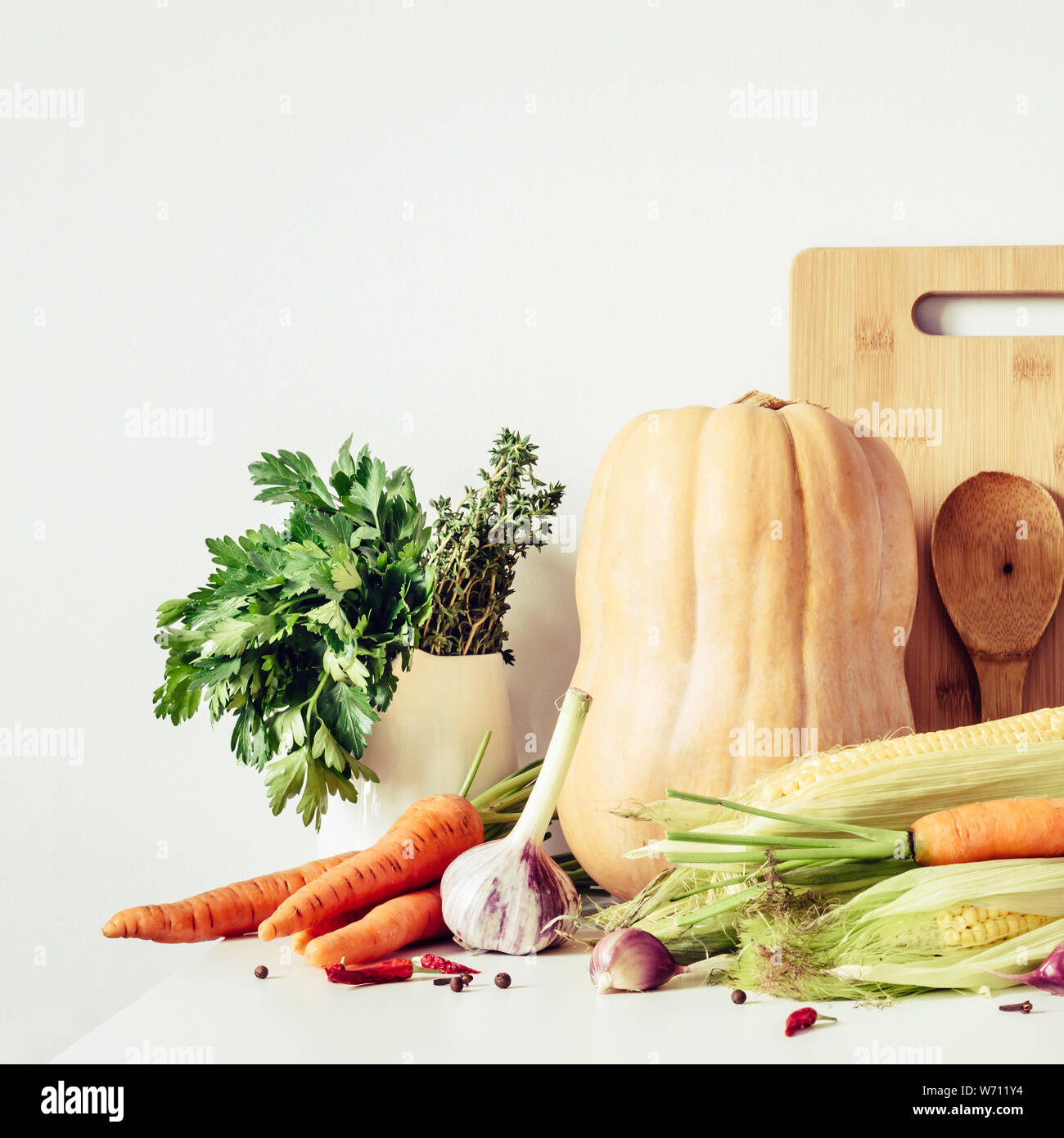 Kürbis und sortierten Herbst Gemüse und Geschirr auf dem Tisch Wand Hintergrund. Stockfoto