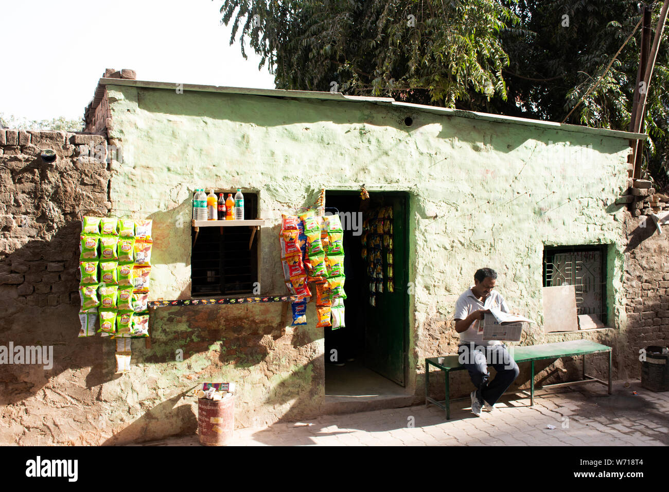 Indische Leute Verkauf und Nahrung und Produkt von lokalen Lebensmittelgeschäft kaufen und Sitzen lesen Zeitung neben Straße in Morgen Zeit in Delhi City am 24. März 2019 Stockfoto