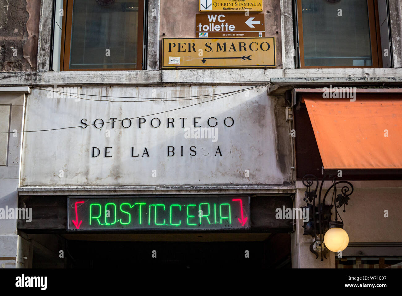 Zeichen an der Wand, auf dem San Marco Platz, öffentliche Toiletten, und  eine Rosticceria in Venedig, Italien Stockfotografie - Alamy