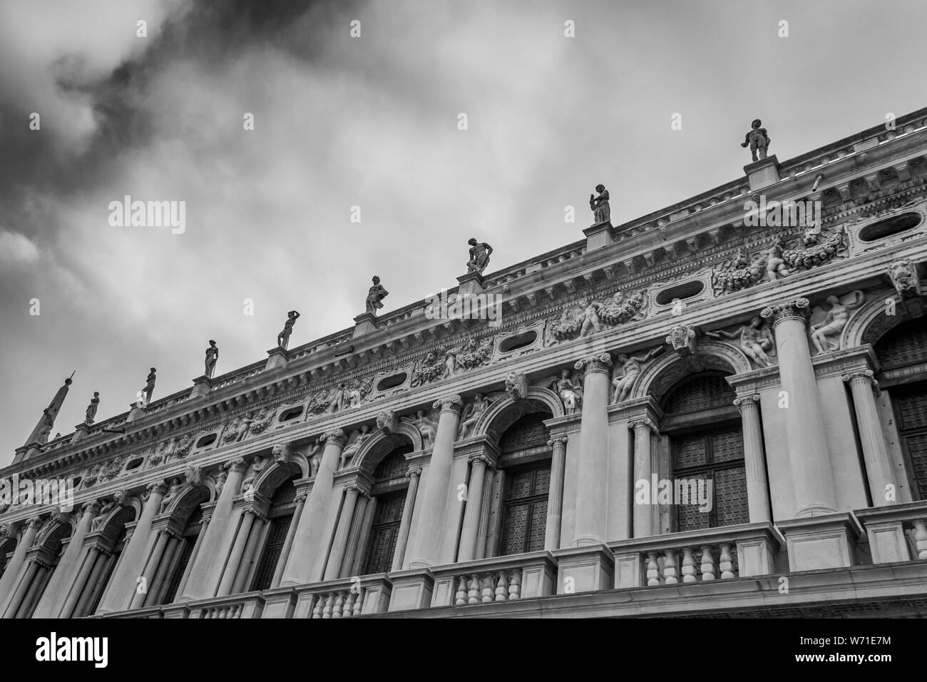 Statuen von mehrere Bildhauer schmücken die obere Kante der Biblioteca Marciana in San Marco, Venedig, Italien. Stockfoto
