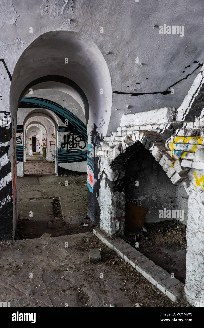 Innenraum mit gewölbter Durchgang und Kamin in verlassenen 19. Jahrhundert Fort Bema in Warschau, Polen, urban Exploration, Wände bedeckt mit Graff Stockfoto