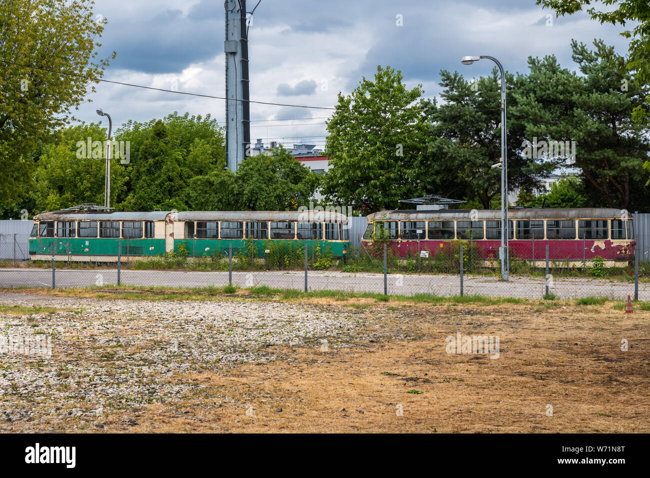 Abgebrochene vintage Straßenbahnen auf der Seite einer alten Depot, grüne und rote Schienenfahrzeuge, veraltete öffentliche Verkehrsmittel in Warschau, Polen Stockfoto