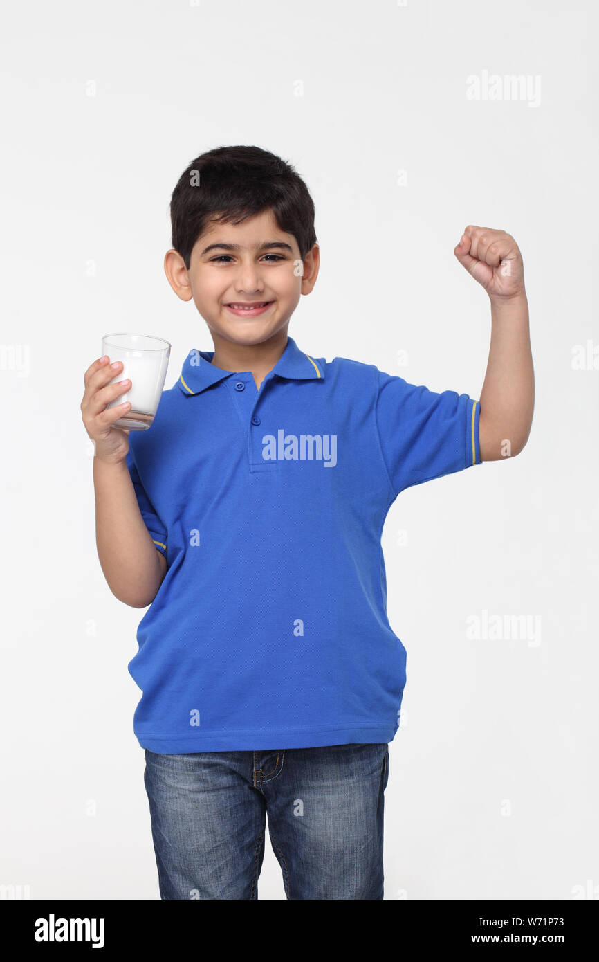 Junge hält ein Glas Milch und Muskeln Stockfoto