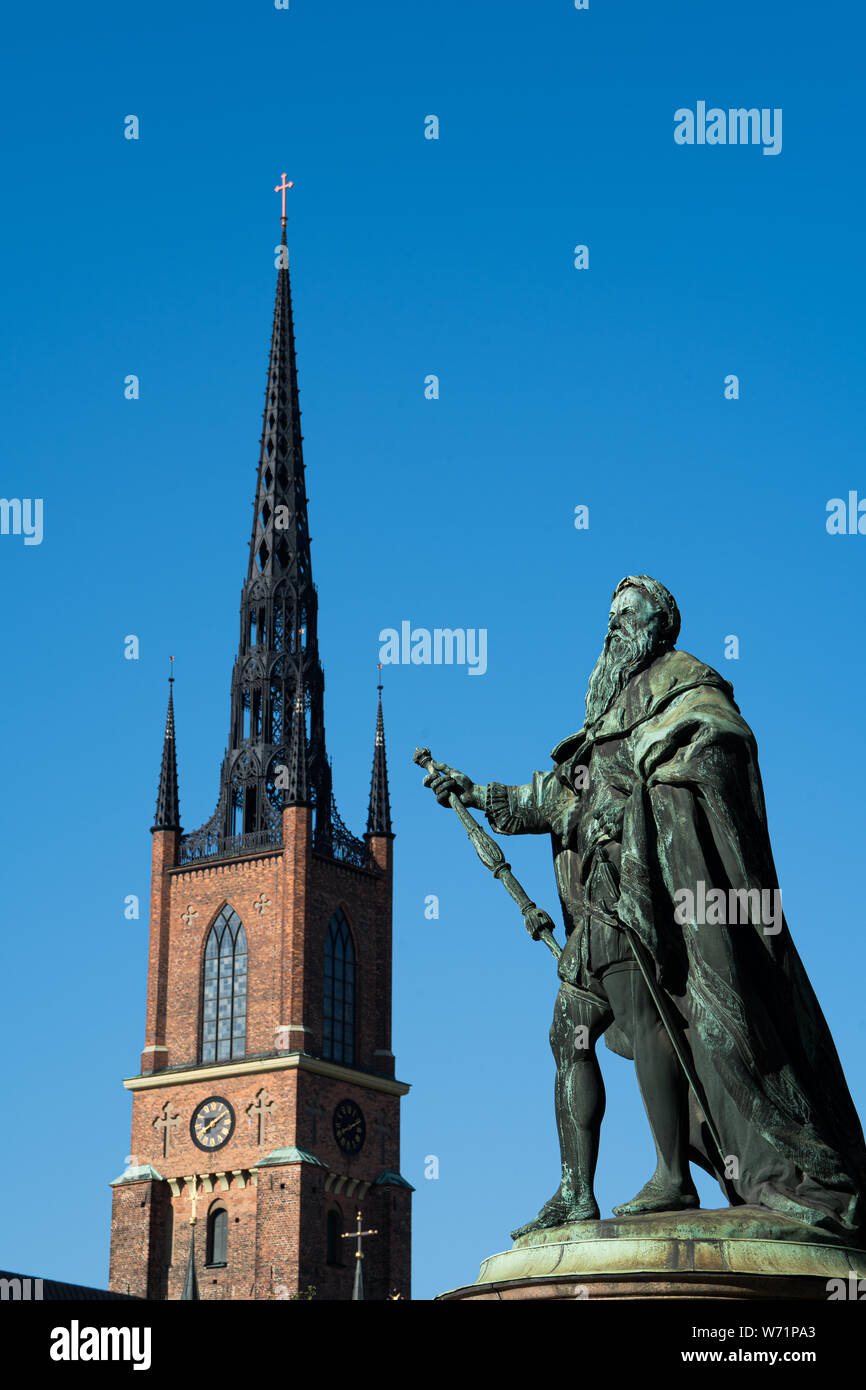 Riddarholm Kirche, der einzigen noch verbliebenen mittelalterlichen Klosterkirche in Stockholm. Franziskaner rotes Ziegelgebäude. Und Gustav Vasa Statue. Stockfoto