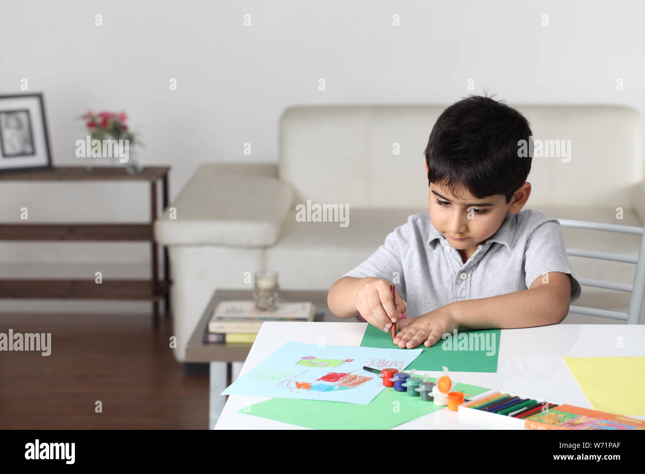 Junge Zeichnung auf einem Blatt Papier zu Hause Stockfoto