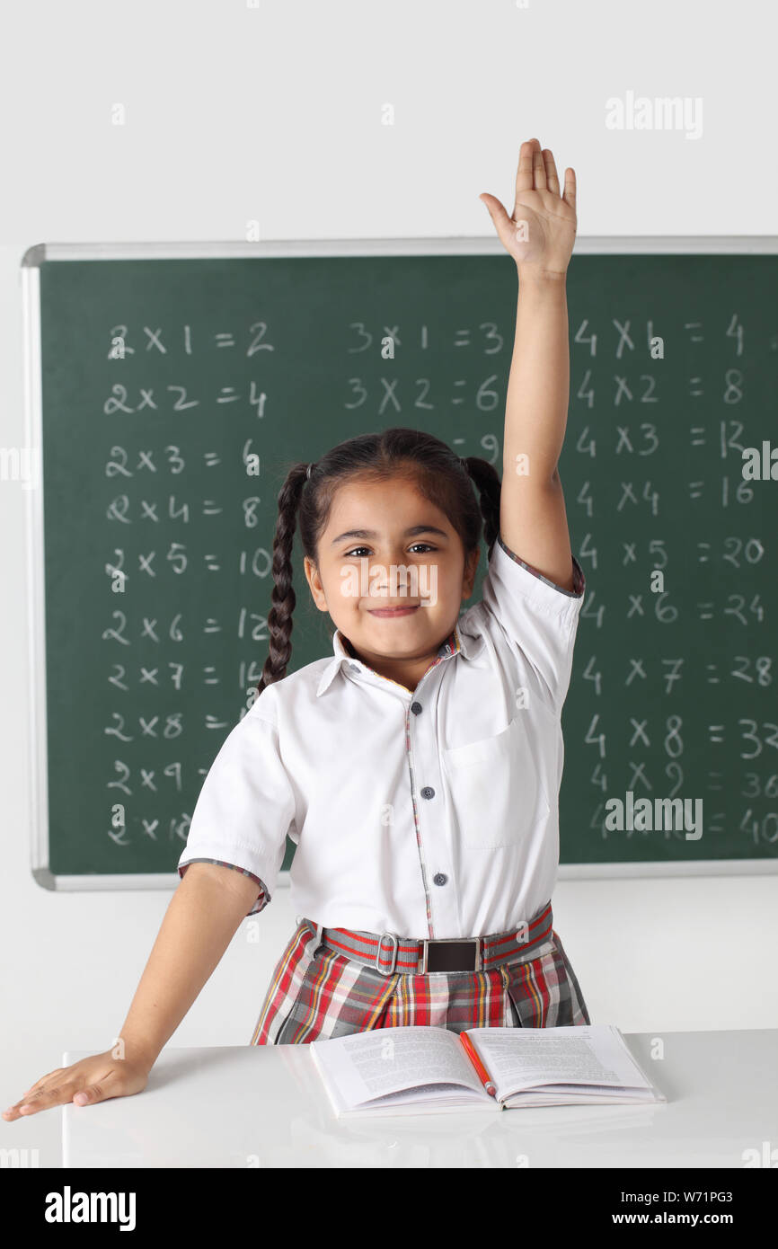 Schulmädchen Erhöhung Hand im Klassenzimmer Stockfoto