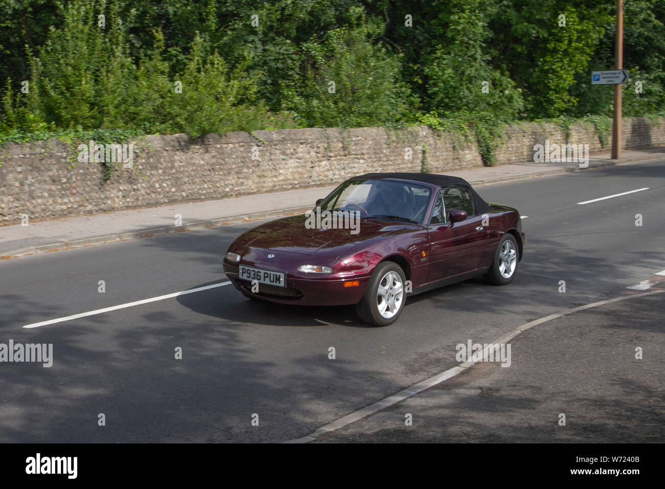 Rote Pflaumenwagen Mazda MX-5 Merlot aus den 1996 90er Jahren auf dem Weg zur Lytham Hall, die klassische Vintage-Festivalfahrzeuge mit Sammlerstücken zeigen. Auf dem Festival of Transport werden verschiedene klassische, Vintage- und prestigeträchtige Sportwagen präsentiert. Stockfoto