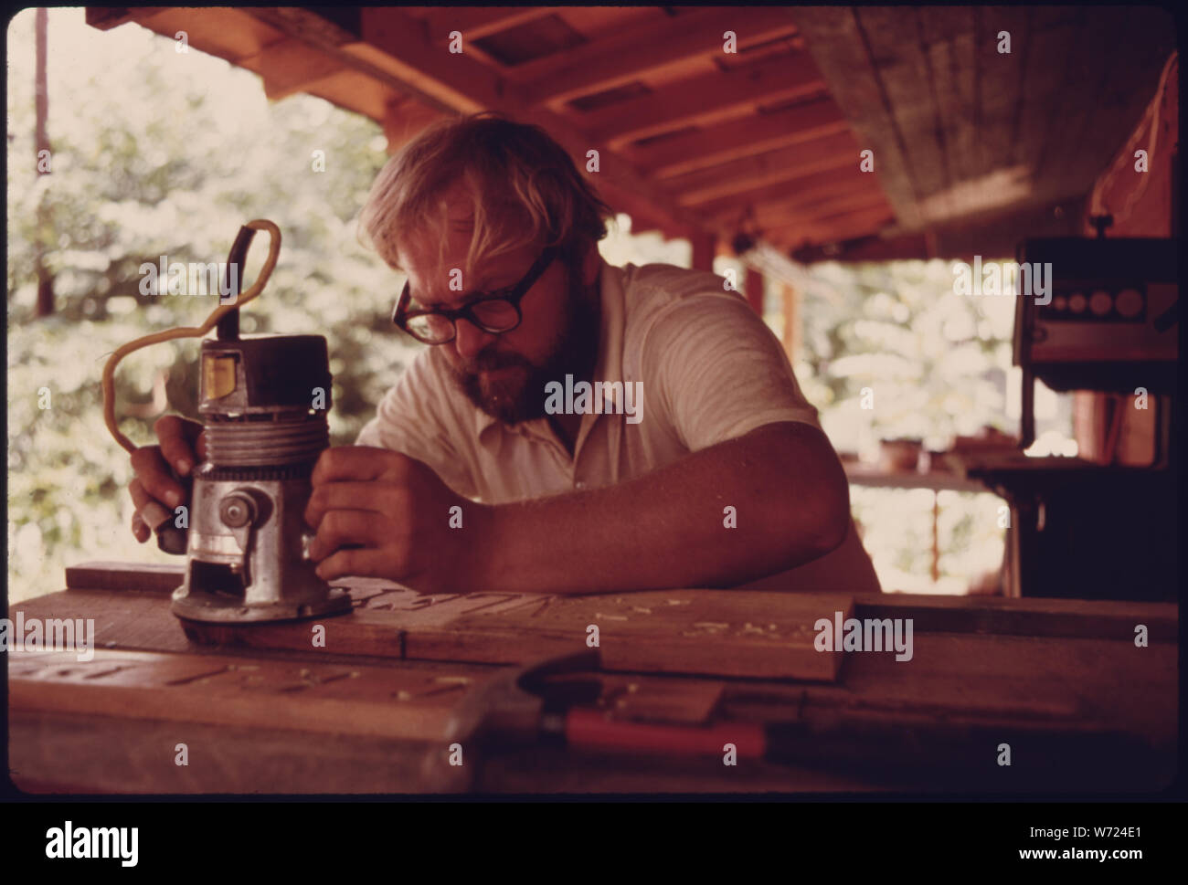 DAVE GALE, einem MITTELGROSSEN ATLANTA AUFTRAGNEHMER FÜR 12 JAHRE NACH Helen, Georgia, 90 Meilen nordöstlich MIT SEINER FAMILIE VON SECHS im Jahr 1974. Er öffnete die WILDEWOOD SHOP, SPEZIALISIERT AUF WANDERN UND KANUFAHREN LIEFERT UND AUSFLÜGE. Er hat ZEICHEN CARVING wie gezeigt auf dem Foto. Neue UNTERNEHMEN WURDEN ANGEZOGEN ZU HELEN, DA DIE STADT BESCHLOSSEN, DAS GESCHÄFTSVIERTEL IN EINEM BAYERISCHEN ALPINE THEME zu renovieren. HELEN IST IN DER NÄHE VON ROBERTSTOWN, Georgien Stockfoto