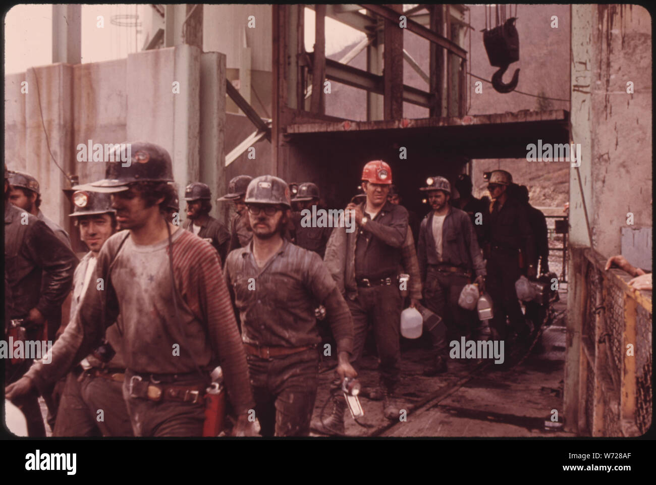 Erste Schicht der Bergleute AN DER VIRGINIA - POCAHONTAS COAL COMPANY MINE #4 in der Nähe von RICHLANDS, Virginia, AUS DEM AUFZUG. Sie werden ersetzt durch die zweite Schicht, die ARBEITEN VON 4 UHR BIS MITTERNACHT ARBEITEN WERDEN. Eine MITTERNACHT BIS MORGEN oder HOOT-OWL WIRD DURCH AUFRÄUMARBEITEN. Viele DER MÄNNER TRAGEN IHRE EIGENE WASSERKRÜGE, LIEBER VON ZU HAUSE AUS ZU TUN, DIE ZUM TRINKEN DIE FIRMA ZUR VERFÜGUNG GESTELLT. Diejenigen, die rauchen über Boden kauen Tabak WÄHREND DER ARBEIT Stockfoto