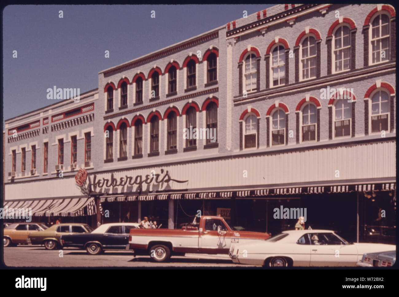 HERBERGERS KAUFHAUS AUF MINNESOTA STREET IN NEW ULM, Minnesota. STORE BEAMTEN RESTAURIERT UND UNIFIED drei Gebäude, die von der Malerei der Ziegel und DETAILARBEIT IN DEN GLEICHEN FARBEN. IN DEN 1960ER JAHREN DOWNTOWN STORES BENÖTIGT ÜBERHOLUNG UND EINIGE STELLENANGEBOTE EXISTIERTE DER GEMEINSCHAFT Pläne gemacht, um die Gegend zu beleben. Die acht BLOCKABSCHNITT HAT JETZT ALLE Vorräte belegt mit STOREFRONTS verbindet zeitgenössisches Design mit restaurierten alten Fassaden, DIE DEUTSCHEN STYLING Stockfoto