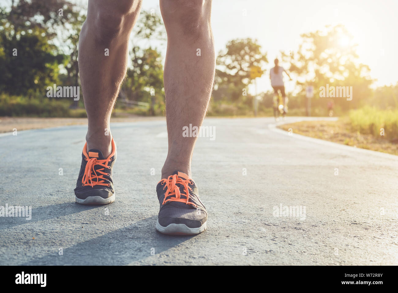 Mann workout Wellness Konzept: Nahaufnahme runner Füße mit Sneaker Schuh laufen auf der Straße in den Park. Fokus auf Shoe. In morgen Zeit, Sonnenlicht und w Shot Stockfoto