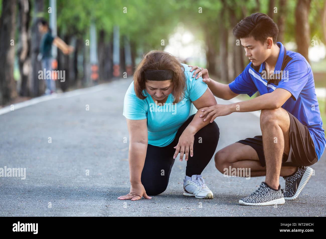 Asiatischer Mann machen, Ermutigung zu fette Frau, die müde und das Sitzen auf dem Boden Stockfoto