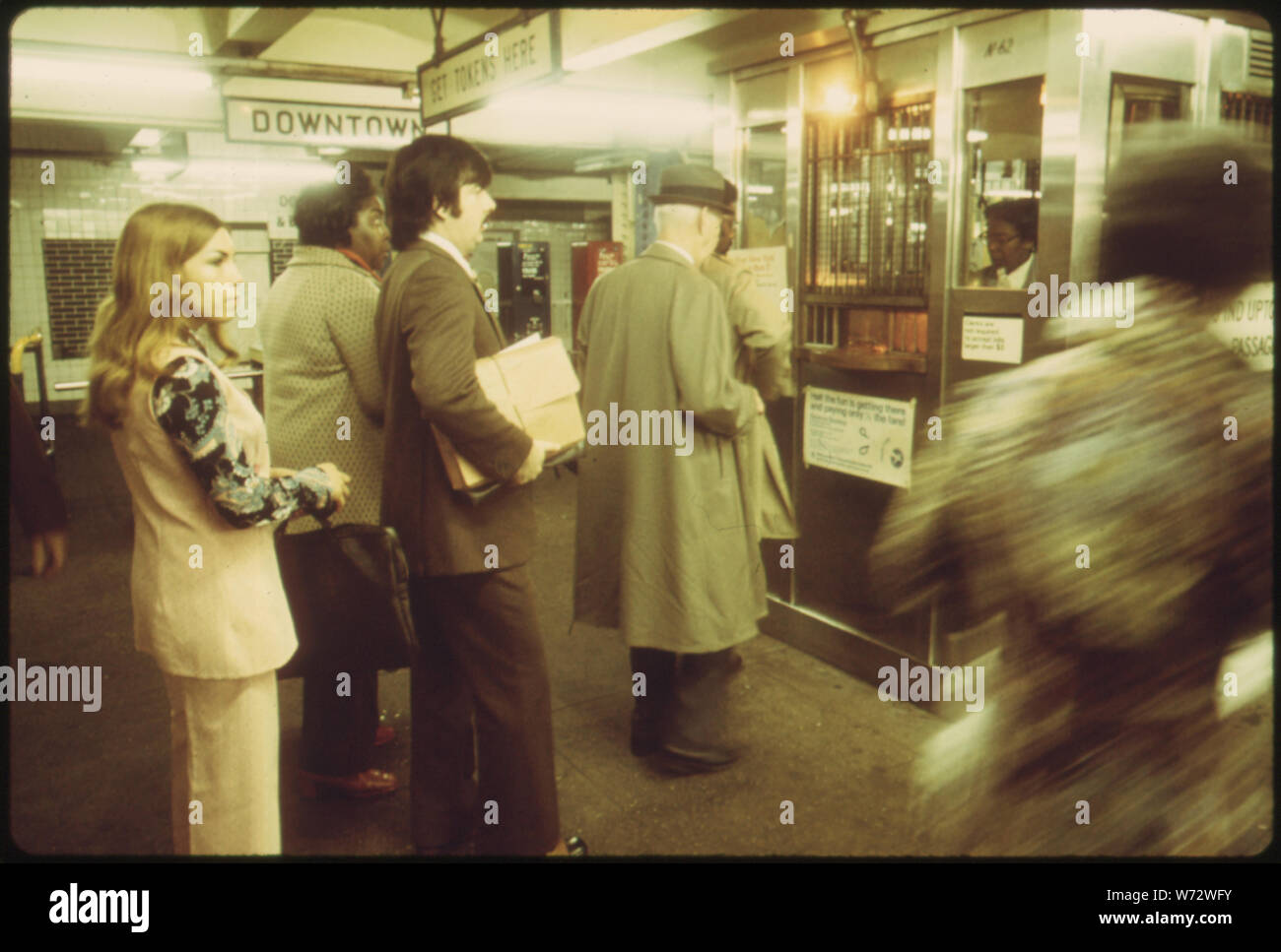 Passagiere warten IN DER LINIE ZU KAUFEN U-ZEICHEN AM 8 TH AVENUE LINIE DER NEW YORK CITY TRANSIT AUTHORITY. Im Jahre 1970 durchschnittlich 2,1 MILLIONEN PERSONEN, MIT DER U-BAHN JEDEN TAG, NÄMLICH 47 PROZENT DER ARBEITSKRÄFTE. Das SYSTEM IST VON ZENTRALER BEDEUTUNG FÜR DIE STADT, ABER DIE WÄHLER HABEN ZU NEUEN FONDS GENEHMIGEN FÜR WEITERE VERBESSERUNGEN, bzw. erhöht 35 abgelehnt - CENT TARIF ZUR DECKUNG DER VERWALTUNGSKOSTEN Stockfoto