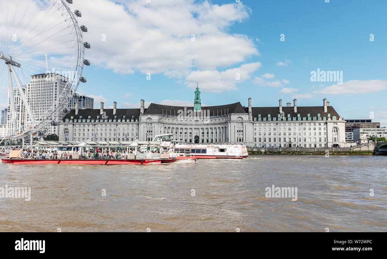 London/UK, 15. Juli 2019 - County Hall und das London Eye, das aus über den Fluss Themse gesehen Stockfoto