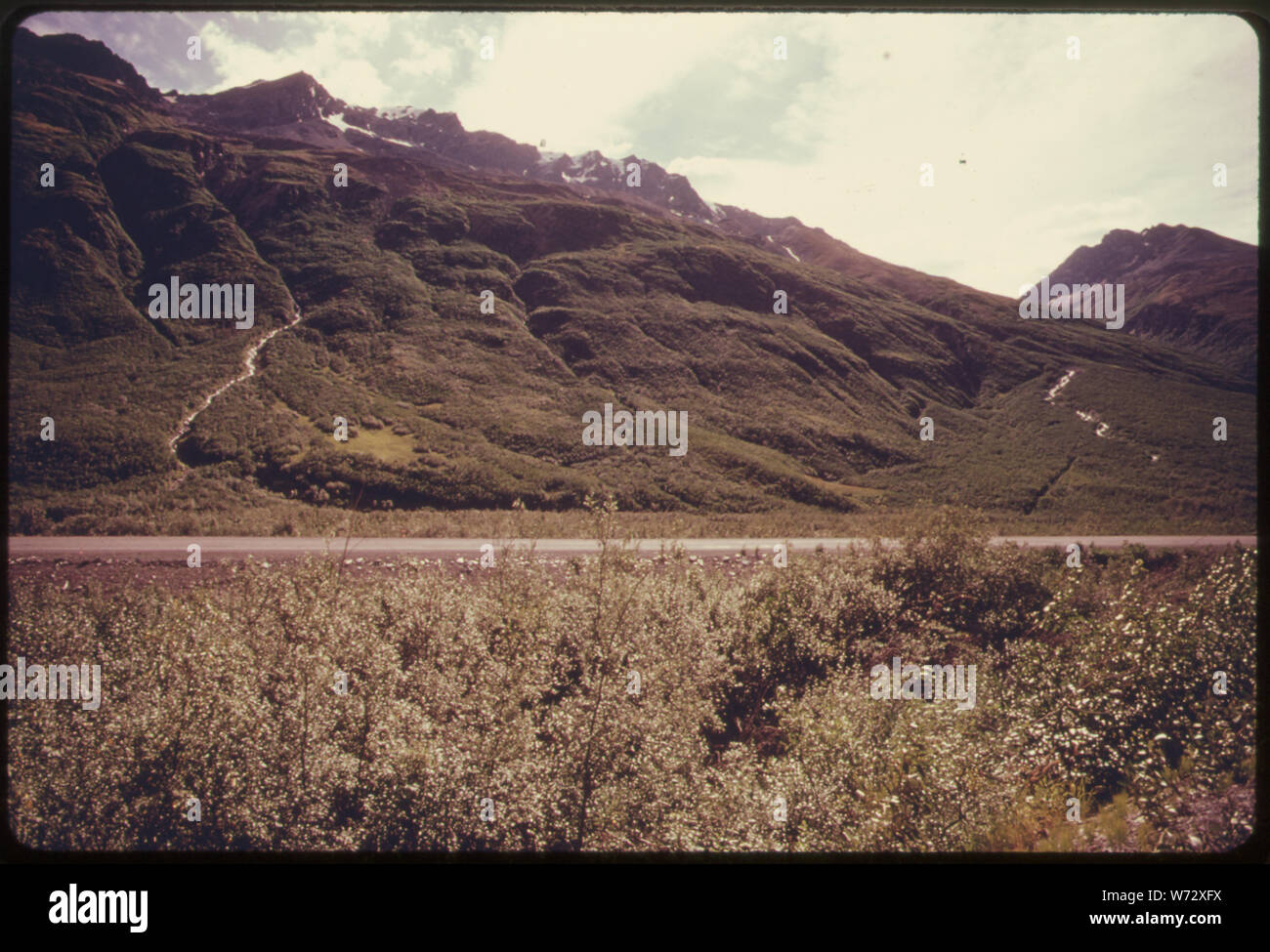 PIPELINE ÜBERQUERUNG DES TSINA FLUSS UND Richardson Highway in Richtung Süden über der Fahrbahn. Der Fluss ist unsichtbar hinter der Straße. Eine VORFAHRT MITTELLINIE WURDE GELÖSCHT. Es IST SICHTBAR IN DER RECHTEN SEITE DES BILDES ALS SCHRÄGSCHNITT absteigend den Hang in Richtung der Kamera. Der Schnitt Winkel scharf rechts, WO DIE DUNKLEN SCHWADEN SCHEINT ZU ENDE AUF DER SEITE. Ab diesem Punkt wird die Linie überqueren Sie den kleinen Bach sichtbar in der oberen rechten Ecke. Meile 745 ALASKA PIPELINE ROUTE Stockfoto
