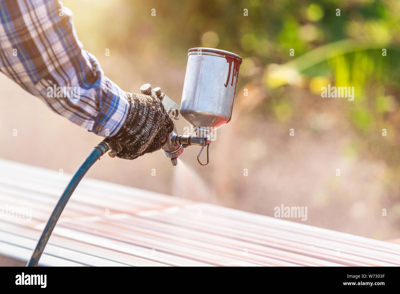 Bauarbeiter Farbe spritzen zu Stahlrohr der Rost auf der Oberfläche zu verhindern. Stockfoto