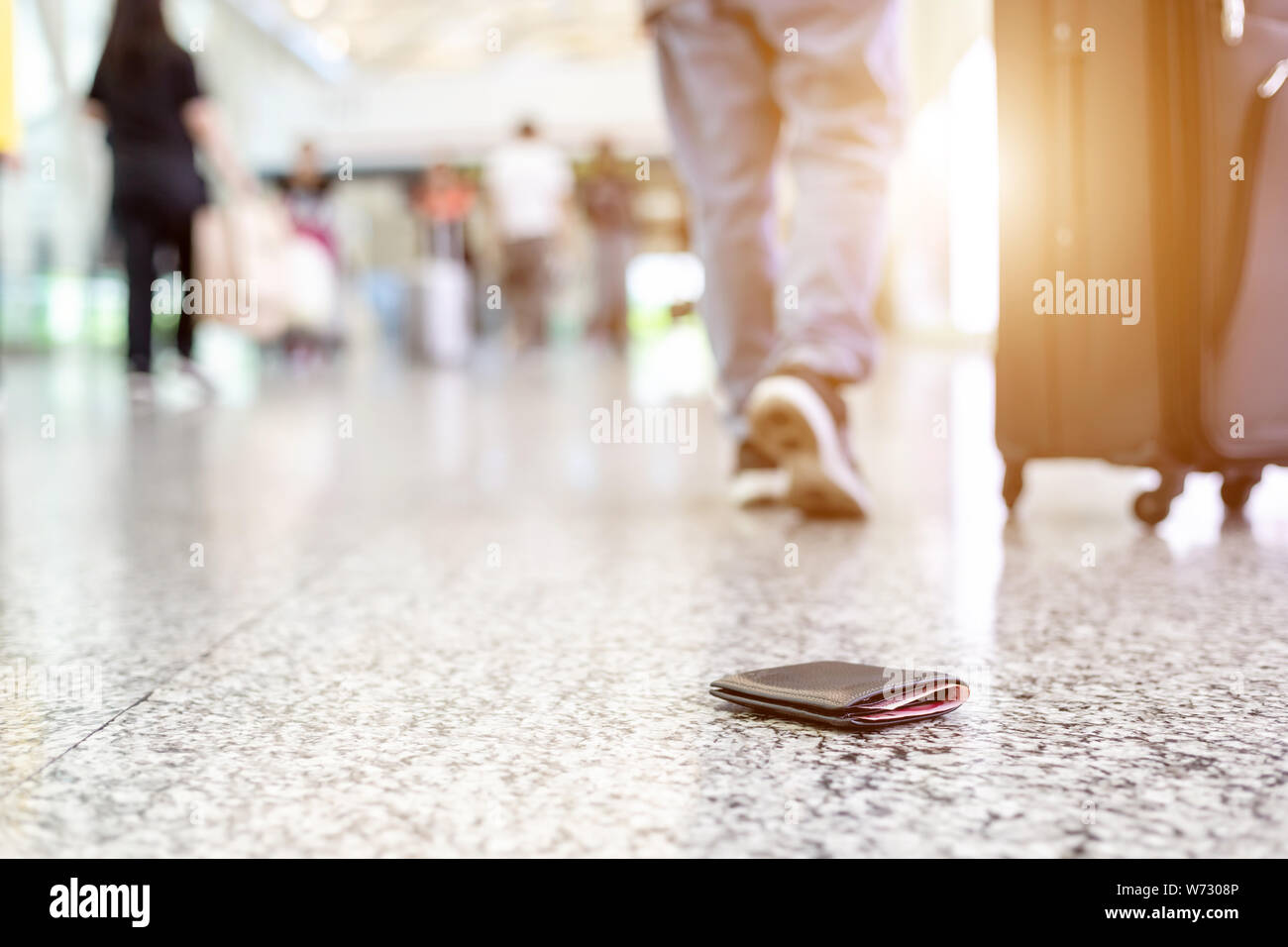 Reisende verloren ihre Brieftasche auf dem Boden am Flughafen. Geld zu verlieren, während Konzept reisen. Fokus auf Wallet Stockfoto