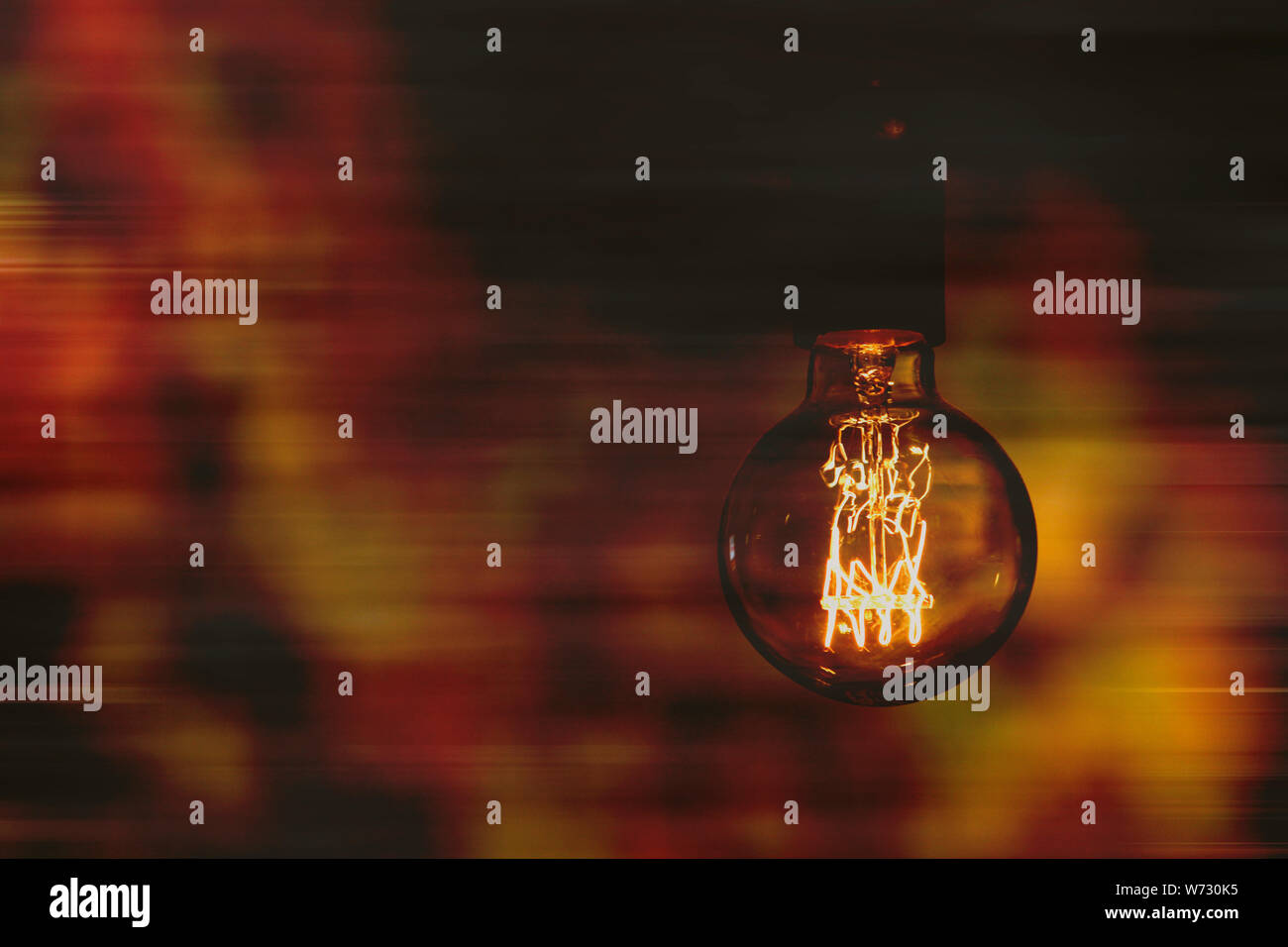 Schließen Sie herauf Bild eines altmodischen Bir runde Glühbirne auf sich schnell bewegenden Hintergrund. Der technologische Wandel conceptç Stockfoto