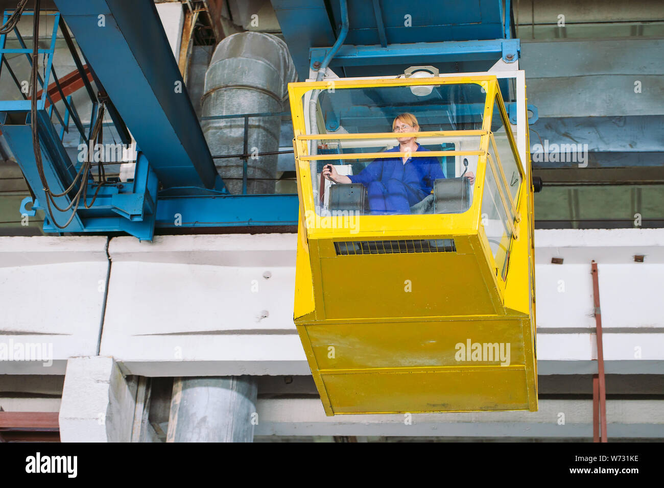 Das Mädchen, das in der Kabine eines Krans. Die Schwerindustrie, Metall Fabrik. Stockfoto