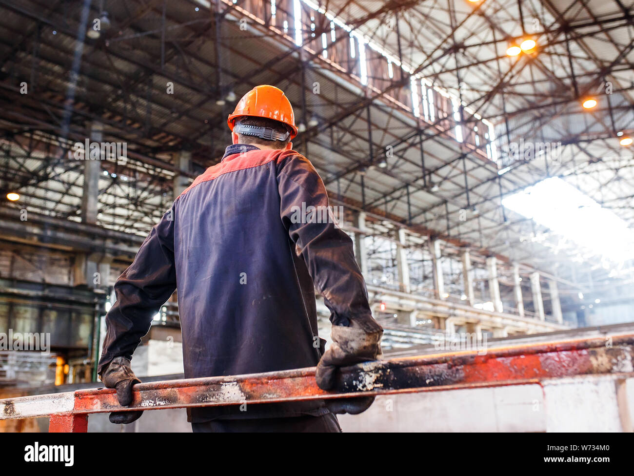 Ein Mann in einer Form auf dem Hintergrund einer metallurgischen Werk. müde von der Arbeit Arbeitnehmer Stockfoto