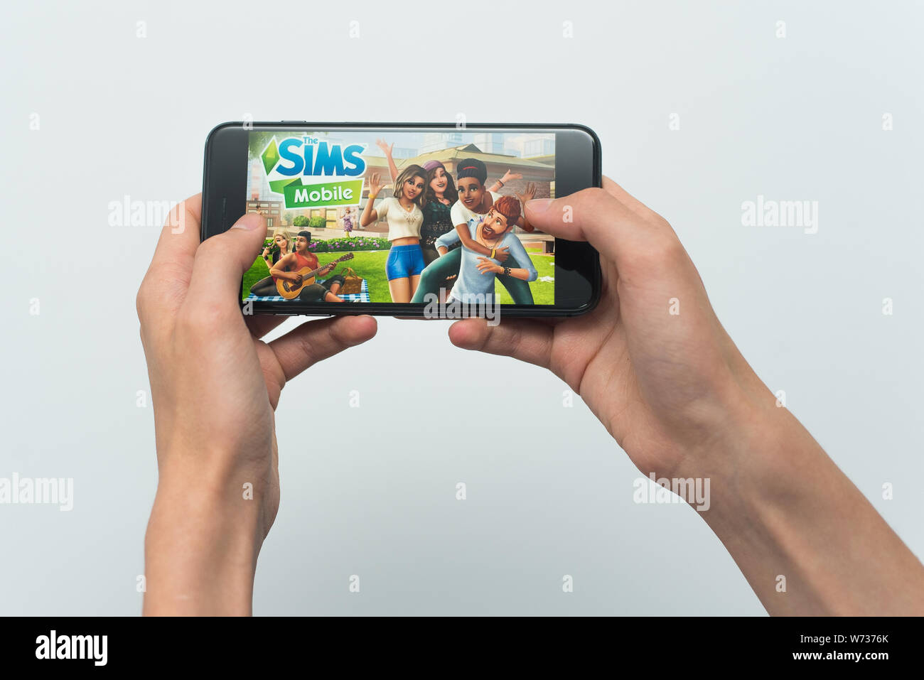 Samara, Russland-07, 29, 2019: ein junger Kerl spielt eine SIMS Spiel auf dem Iphone 8 Plus. Teenager hält ein Handy in der Hand mit einem Spiel Sims Mobile auf dem wh Stockfoto