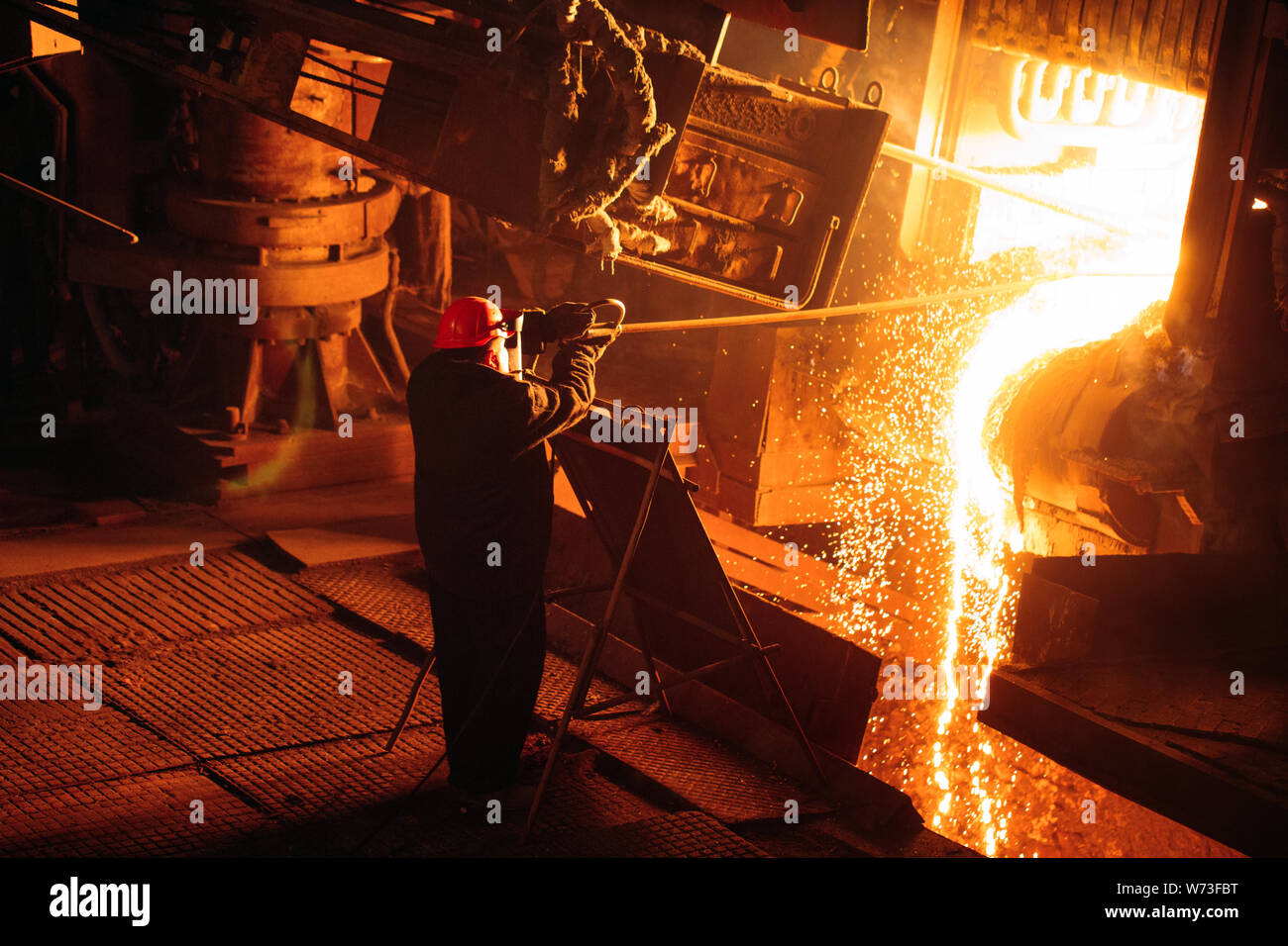 Anlage zur Herstellung von Stahl. Einen elektrischen Schmelzofen. Arbeiter wird eine Probe für Metall. Stockfoto