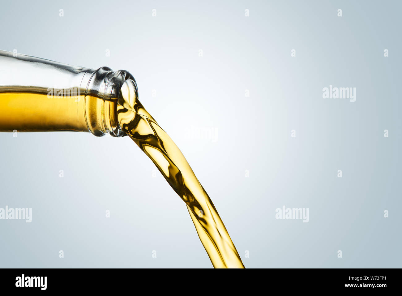 Nahaufnahme des Golden ale Ausgießen aus der Flasche an kühlen grauen Hintergrund. Stockfoto