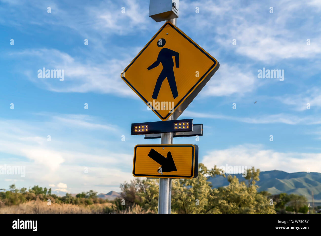 Fußgängerüberweg Zeichen und diagonalen Pfeil rechts Schild mit blinkenden Lichtern Stockfoto