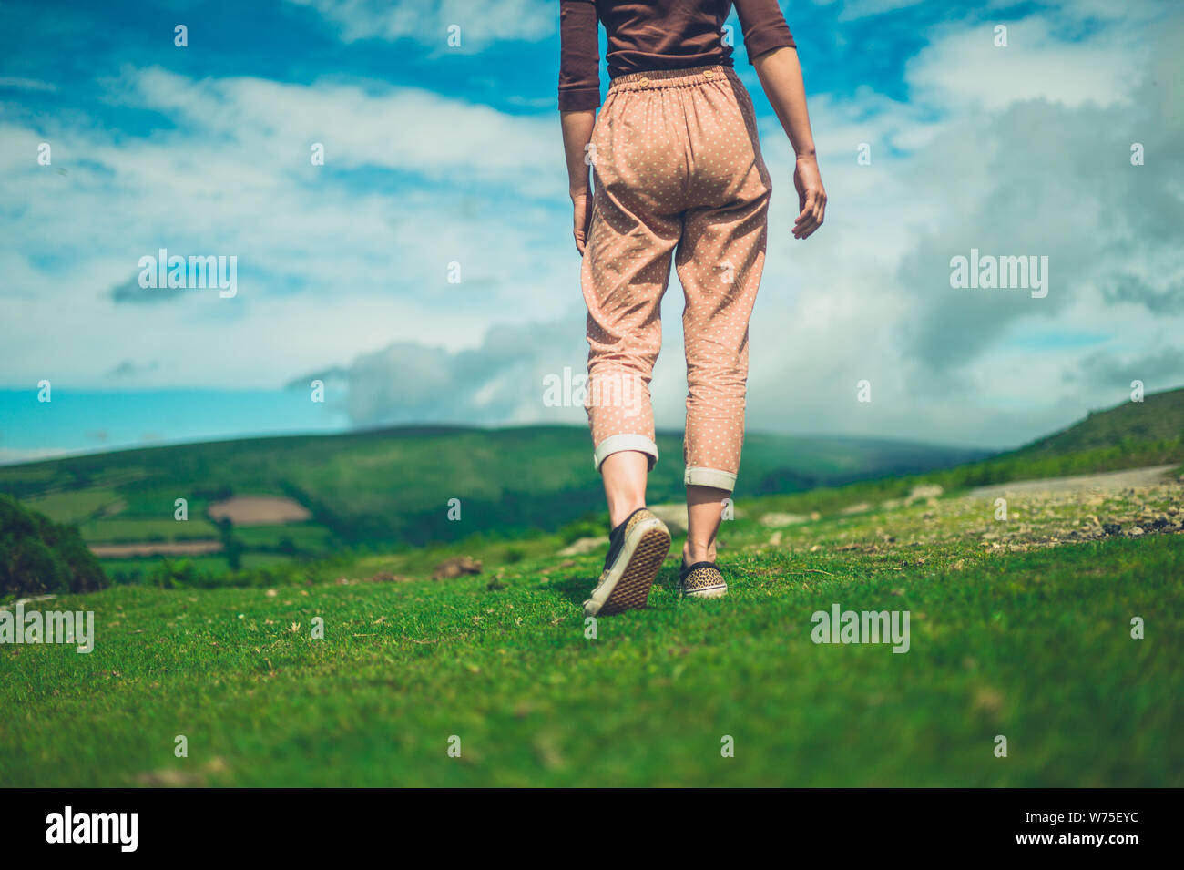 Eine junge Frau wird zu Fuß in der Wüste an einem sonnigen Sommertag Stockfoto