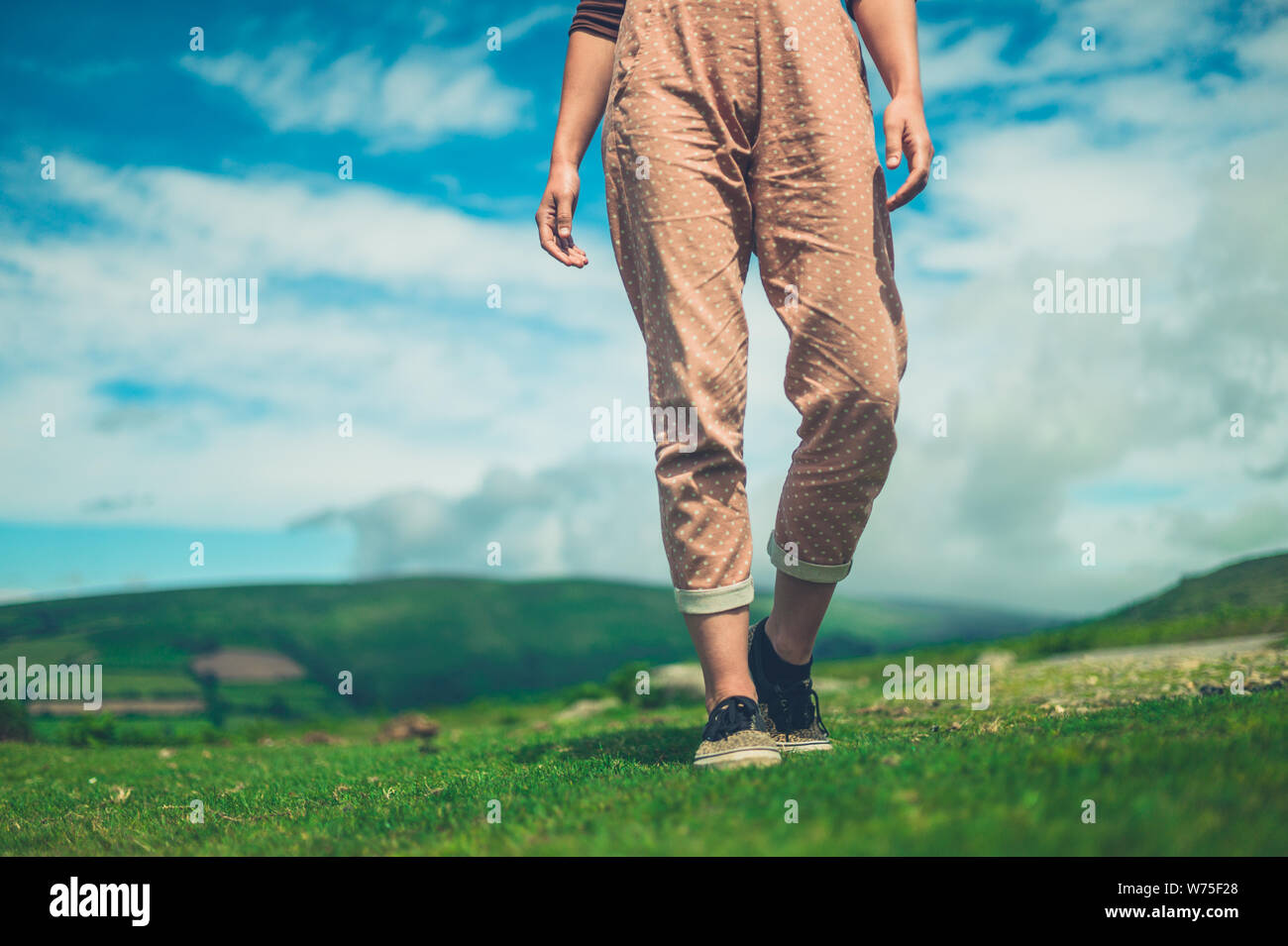 Eine junge Frau wird zu Fuß in der Wüste an einem sonnigen Sommertag Stockfoto