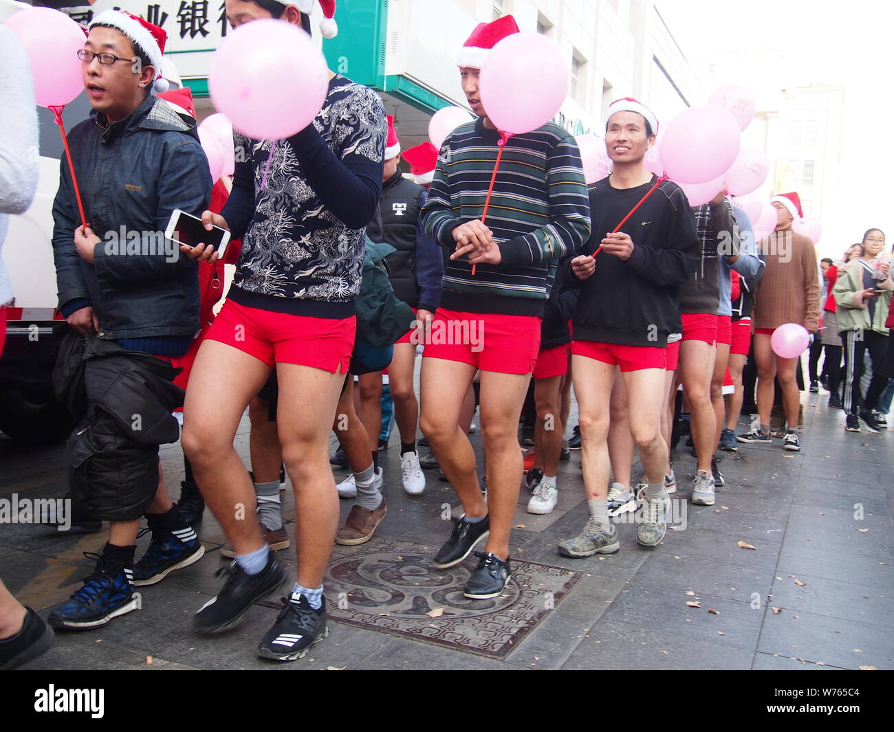 Spärlich bekleideten Menschen während einer Parade Weihnachten Santa Undie Run auf einer Straße in Ji'nan Stadt feiern, der ostchinesischen Provinz Shandong, 24. Dezember 2017 Stockfoto