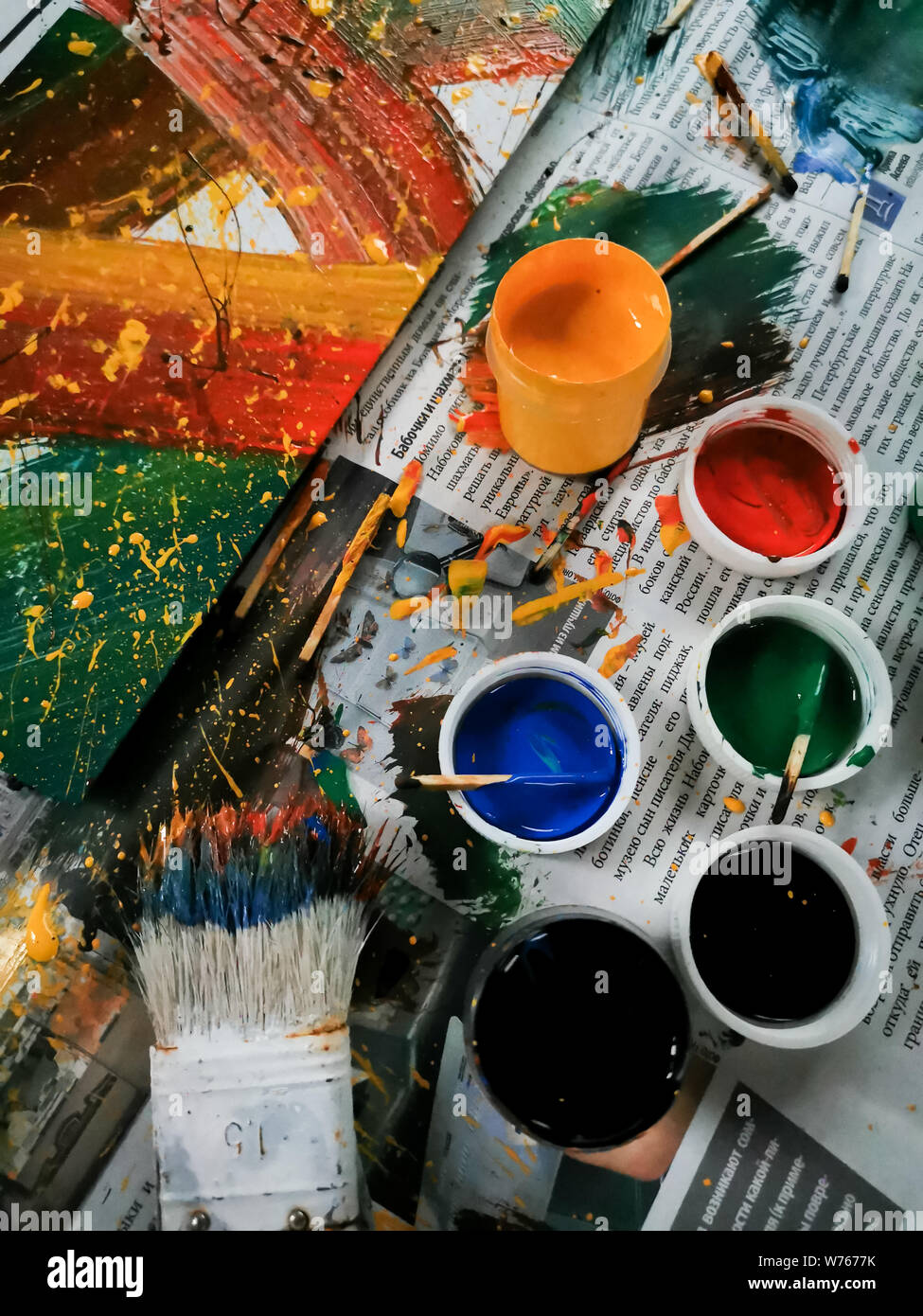 Bunte, helle Farben, Pinsel und abstrakte Malerei auf Zeitung Hintergrund. Dosen in verschiedenen Farben und zeitgenössische Kunst Stockfoto