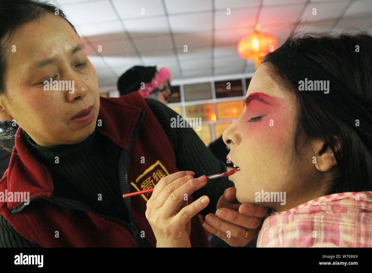 ---- Ein fremder Besucher beendet ihre Make-up mit Hilfe eines chinesischen Sichuanese oper Künstler nach einer Show im Backstage in Chengdu City, southwes Stockfoto