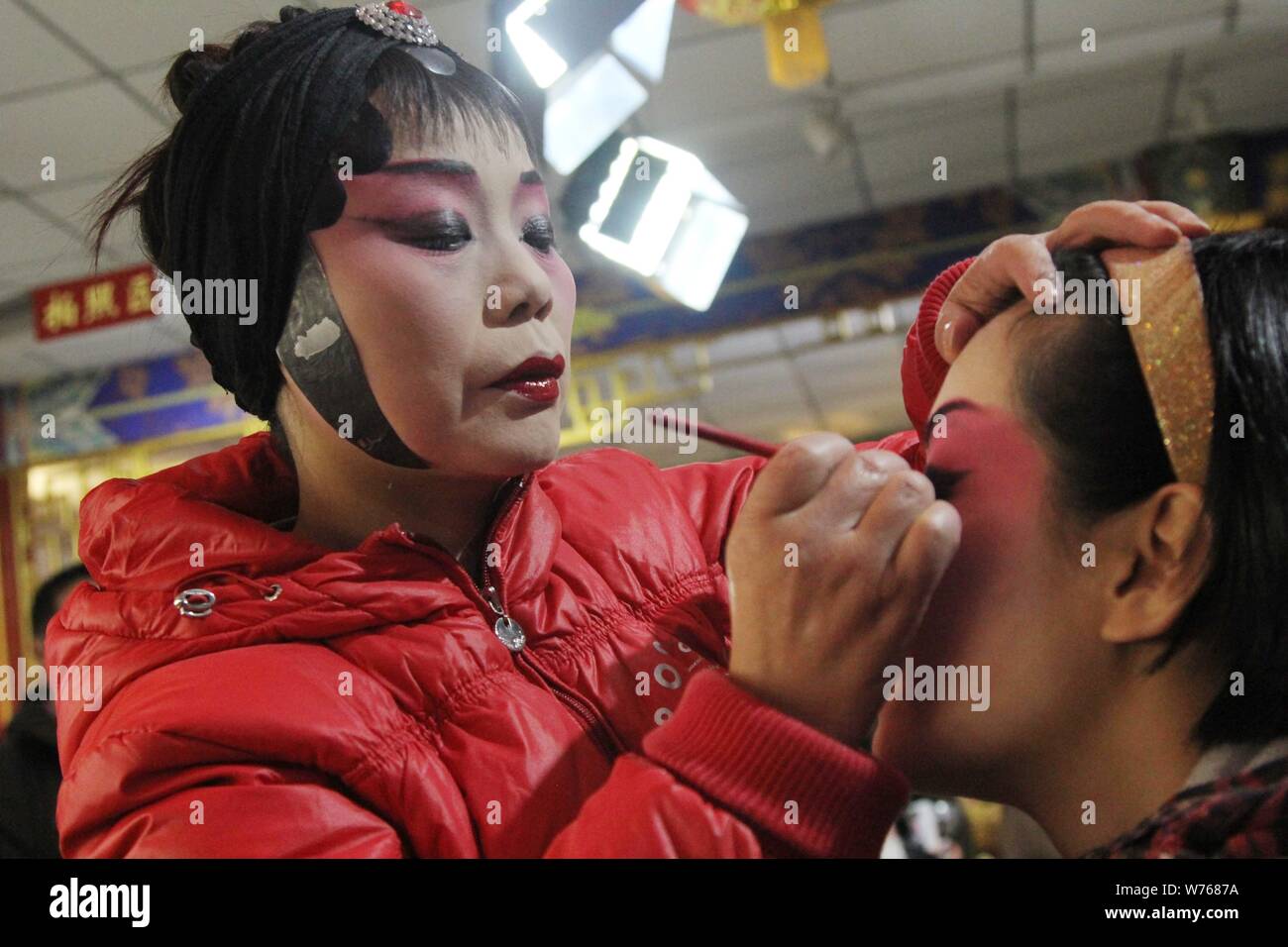---- Ein Besucher beendet ihre Make-up mit Hilfe eines chinesischen Sichuanese oper Künstler nach einer Show im Backstage in Chengdu City, im Südwesten von China" Stockfoto