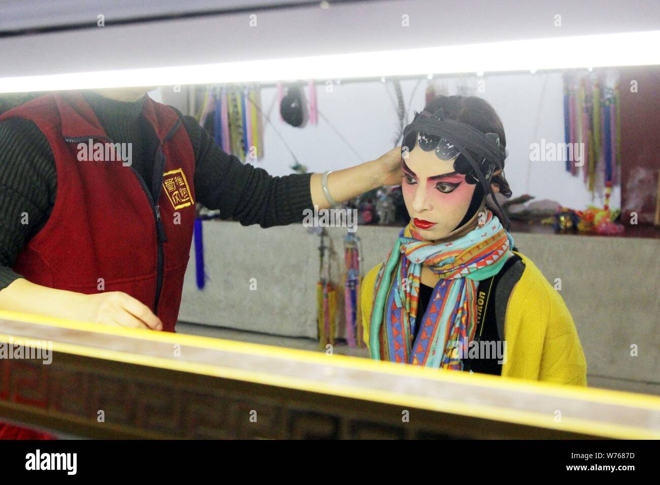---- Ein fremder Besucher beendet ihre Make-up mit Hilfe eines chinesischen Sichuanese oper Künstler nach einer Show im Backstage in Chengdu City, southwes Stockfoto