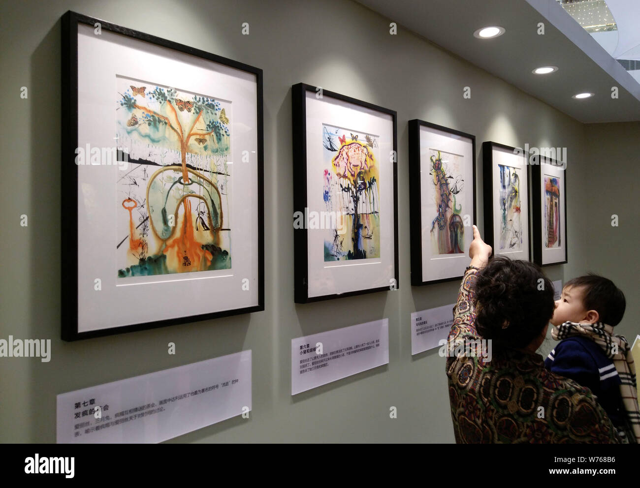 Besucher der Holzschnitt Stücke des spanischen Surrealisten Salvador Dali Look ist auf dem Display während einer Ausstellung in Dalian im Nordosten Chinas Liao Stockfoto