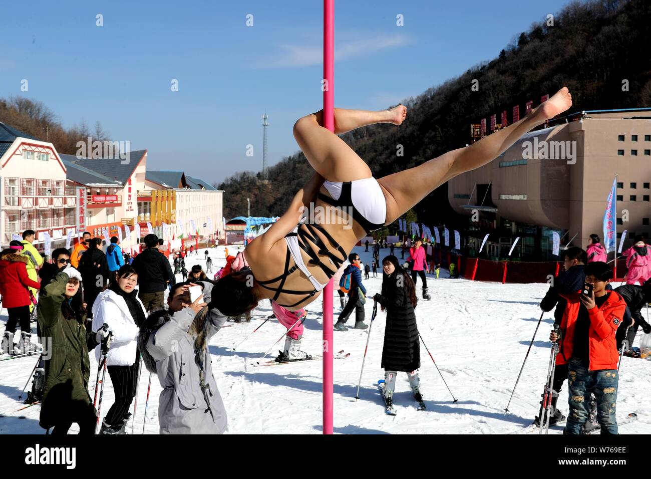 Chinesische Mädchen tragen Bikinis durchführen Pole Dance vor Kälte an einem Ski Park in Luanchuan County, Luoyang City, Central China Provinz Henan, 3. Dezember Stockfoto