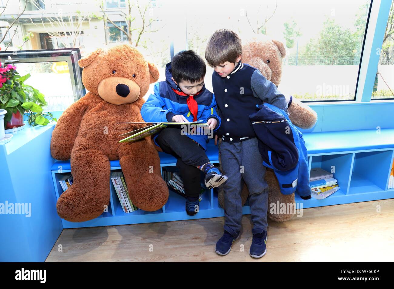 Schüler Bücher lesen und Spaß haben in einer Bibliothek Bus in Nanjing Zhiyuan Fremdsprache Grundschule in Nanjing City, East China Jinagsu Provinz, 29. Stockfoto