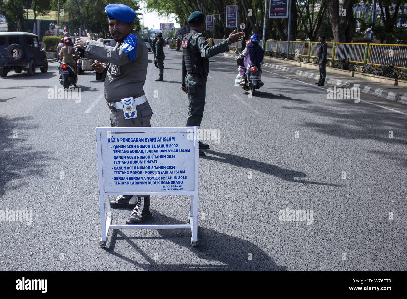 Lhokseumawe, Aceh, Indonesien. 5 Aug, 2019. Die islamische Scharia Polizisten stand Guard auf Autobahnen während der islamischen Scharia Durchsetzungsmaßnahmen in Lhokseumawe. Zuwiderhandlungen der islamischen Scharia regeln, engen Hosen und Shorts sind ein Sarong ihren, und werden durch die Scharia Polizisten festgestellt wird, sie nicht zu wiederholen, während die weiblichen Passagiere von gebietsübergreifenden beim Sitzen auf dem Motorrad verboten sind. Aceh ist die meisten konservativen Provinz in Indonesien über die islamische Scharia. Credit: zikri Maulana/ZUMA Draht/Alamy leben Nachrichten Stockfoto