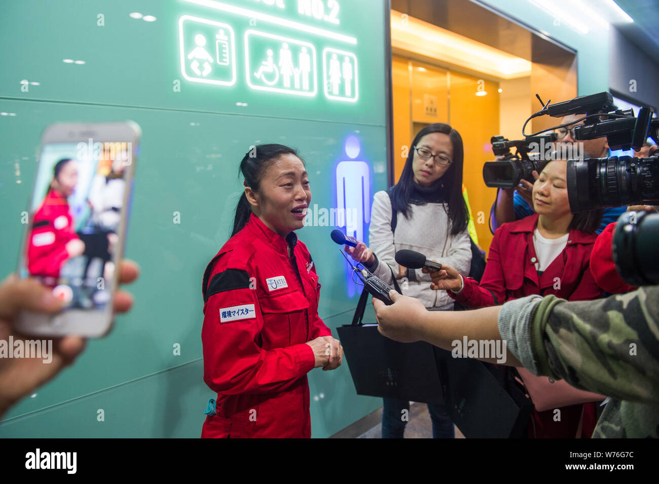 Japanische Reinigung Arbeitnehmer Haruko Niitsu in einer Toilette im Shenzhen Bahnhof Nord in Shenzhen City interviewt wird, die südchinesische Provinz Guangdong Stockfoto