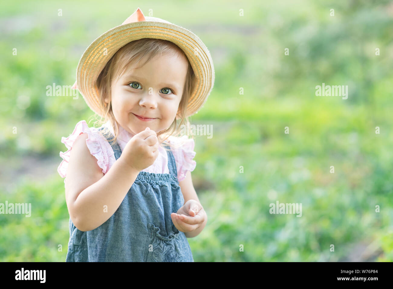 Portrait von Kind Mädchen essen pea Pod im Freien. Ernte Mädchen Erbsen in Garten im Sommer. Helthy Essen für Kinder. Gartenbau, Gärtner, wenig Landwirt Kind Stockfoto